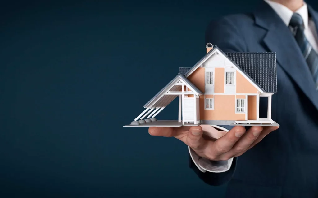 this image displays an expret immigration consultant is holding a proto type house for his client who they got successfully received there green card of their desrired contry for reseidency by investment program.